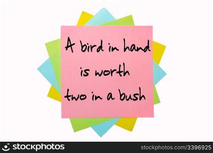 "text "A bird in hand is worth two in a bush" written by hand font on bunch of colored sticky notes"
