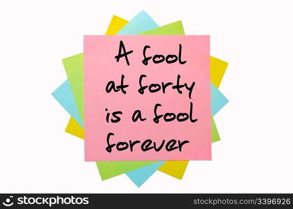 "text "A fool at forty is a fool forever" written by hand font on bunch of colored sticky notes"