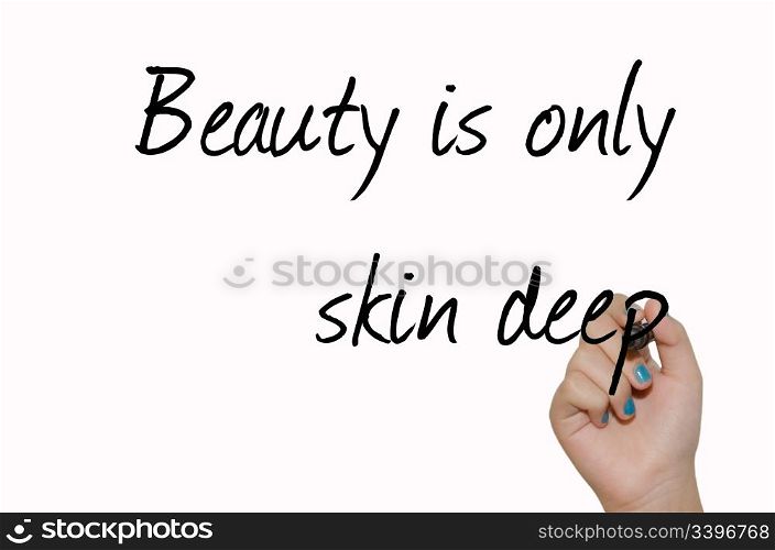 "text "Beauty is only skin deep" black handwrite font on white surface and child&rsquo;s arm holding marker"
