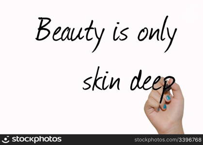 "text "Beauty is only skin deep" black handwrite font on white surface and child&rsquo;s arm holding marker"