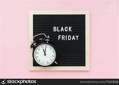 Text Black friday on black letter board and alarm clock on pink background. Concept Black friday , season sales time. Flat lay Top view Copy space Template layout for your design.. Text Black friday on black letter board and alarm clock on pink background. Concept Black friday , season sales time. Flat lay Top view Copy space Template layout for your design