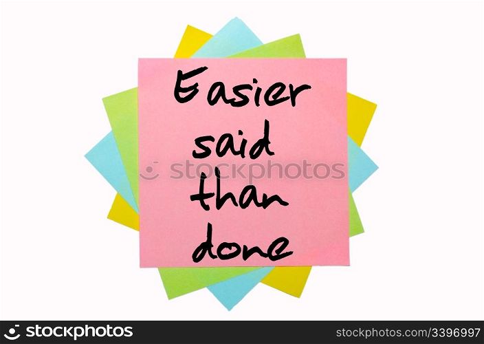 "text "Easier said than done" written by hand font on bunch of colored sticky notes"