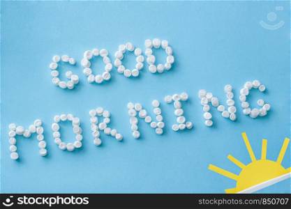 "Text "Good Morning" from marshmallows and figure of rising sun on blue background. Concept"