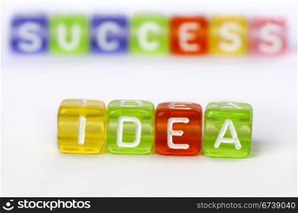 Text Idea and success on colorful wooden cubes over white