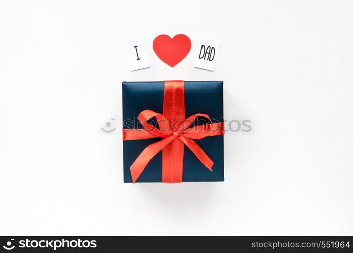 Text message and Blue Gift box wrapped in red ribbon on white background. Top view. Copyspace.. Text message, red paper heart and Blue Gift box wrapped in red ribbon on white background. Top view. Copyspace