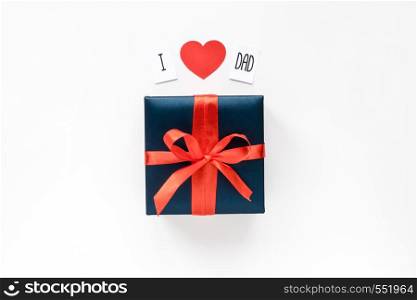 Text message and Blue Gift box wrapped in red ribbon on white background. Top view. Copyspace.. Text message, red paper heart and Blue Gift box wrapped in red ribbon on white background. Top view. Copyspace