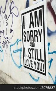 Text poster glued to the wall. I amsorry and I stilllove You.