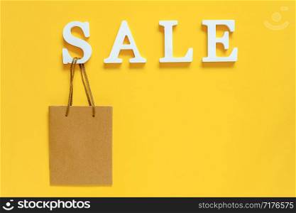 Text SALE from white volume letters and blank shopping bag on yellow background. Top view Flat lay Copy space Concept discount. Creative template for your text, design, ad or advertisement.. Text SALE from white volume letters and blank shopping bag on yellow background. Top view Flat lay Copy space Concept discount. Creative template for your text, design, ad or advertisement
