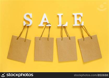 Text SALE from white volume letters and blank shopping bags on yellow background. Top view Flat lay Mockup Concept discount. Creative template for your text, design, ad or advertisement.. Text SALE from white volume letters and blank shopping bags on yellow background. Top view Flat lay Mockup Concept discount. Creative template for your text, design, ad or advertisement