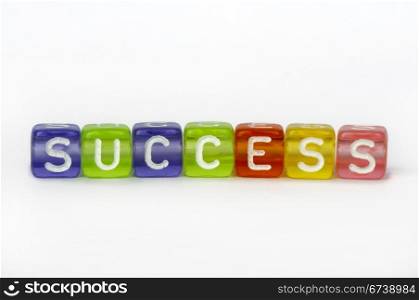 Text success on colorful wooden cubes over white