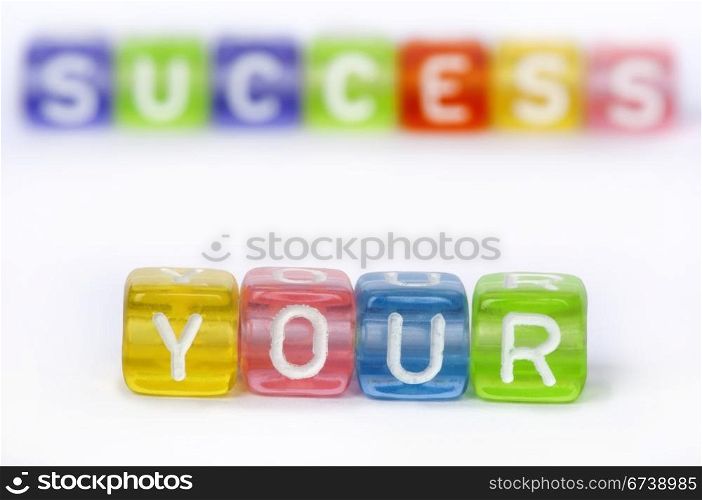 Text Your success on colorful wooden cubes over white