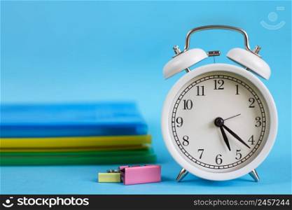 Textbooks and alarm clock on a blue background. Back to school. Library, education. Concept Education or business. Textbooks and alarm clock on a blue background. Back to school. Concept Education or business