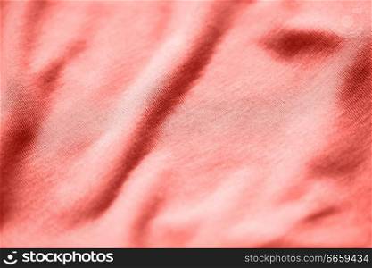 textile and texture concept - close up of cotton jersey fabric background in trendy color of the year 2019 living coral. textile or fabric texture in living coral color