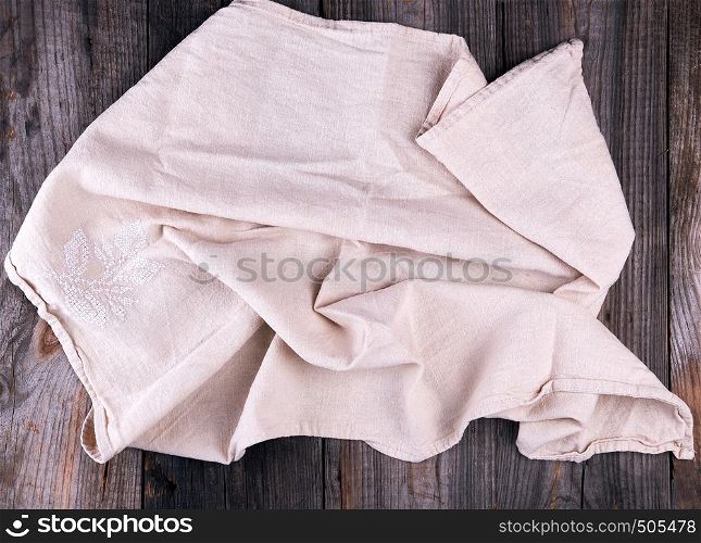 textile dishcloth with embroidery on a gray wooden background from old boards, top view
