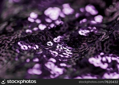textile, party and texture concept - close up of shimmering violet fabric with sequins background. shimmering violet fabric with sequins background