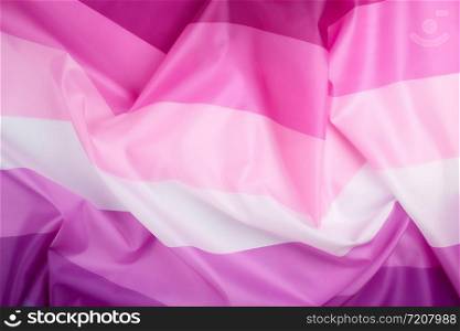 textile pink flag of lesbians, concept of the fight for equal rights and against discrimination, surface waves, full frame