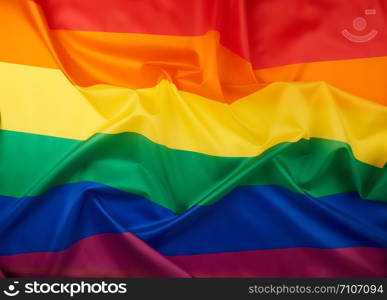 textile rainbow flag with waves, symbol of freedom of choice of lesbians, gays, bisexuals and transgender people, LGBT culture