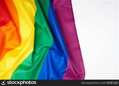 textile rainbow flag with waves, symbol of freedom of choice of lesbians, gays, bisexuals and transgender people, LGBT culture, copy space