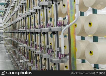 textile yarn on the warping machine. machinery and equipment in a textile factory. textile yarn processing shop