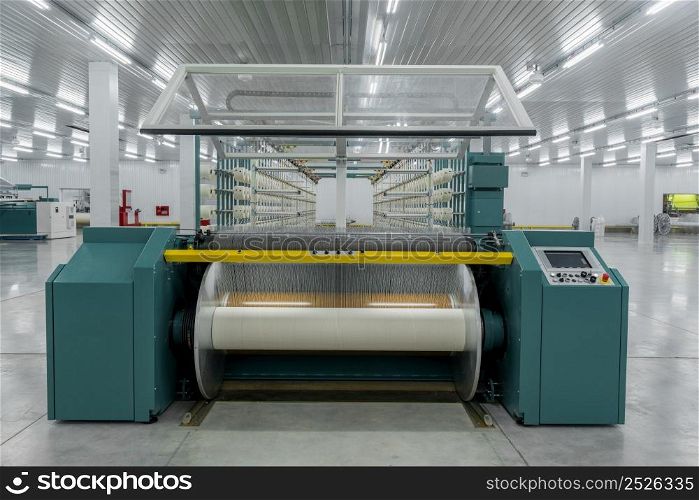 textile yarn on the wrapping machine is screwed on the big shaft. machinery and equipment in a textile factory. textile yarn processing shop