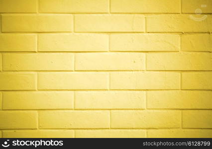 Texture of a brick wall painted with yellow paint