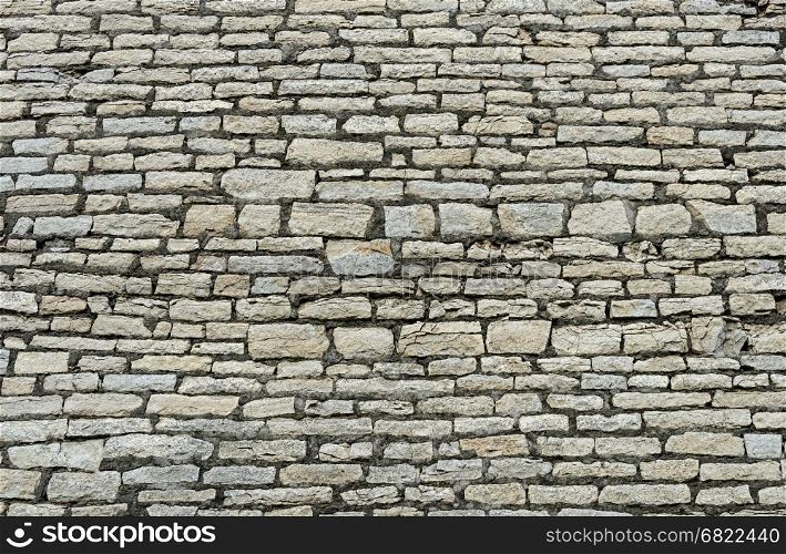 Texture of ancient gray city wall in Pskov, Russia