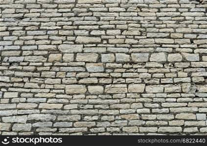Texture of ancient gray city wall in Pskov, Russia