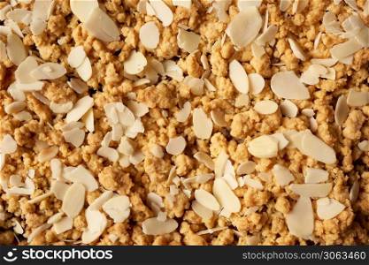 texture of baked crumble pie with fruit filling and sprinkled with grated almonds, full frame