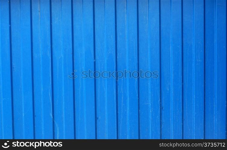 Texture of corrugated metal fence painted with blue paint