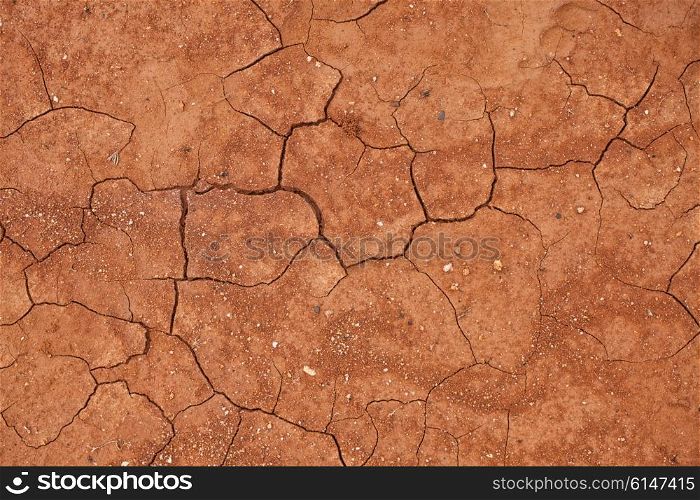 Texture of cracked red clay soil closeup