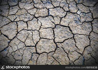 Texture of cracked soil surface in dry season, gray tone vignette background