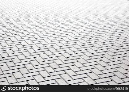 Texture of gray patterned paving tiles on the ground of street, perspective view.
