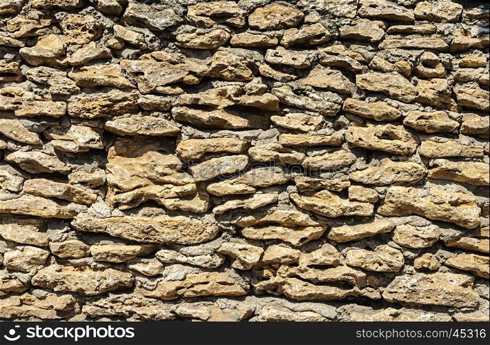 Texture of old brown coquina stones wall with cement mortar
