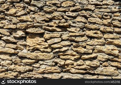 Texture of old brown coquina stones wall with cement mortar