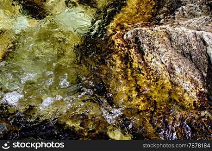Texture of rapid bubbling flow of water and stones