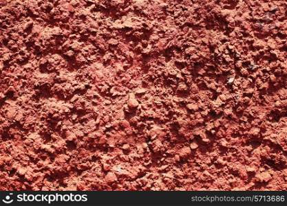 Texture of red bumpy cement wall close up