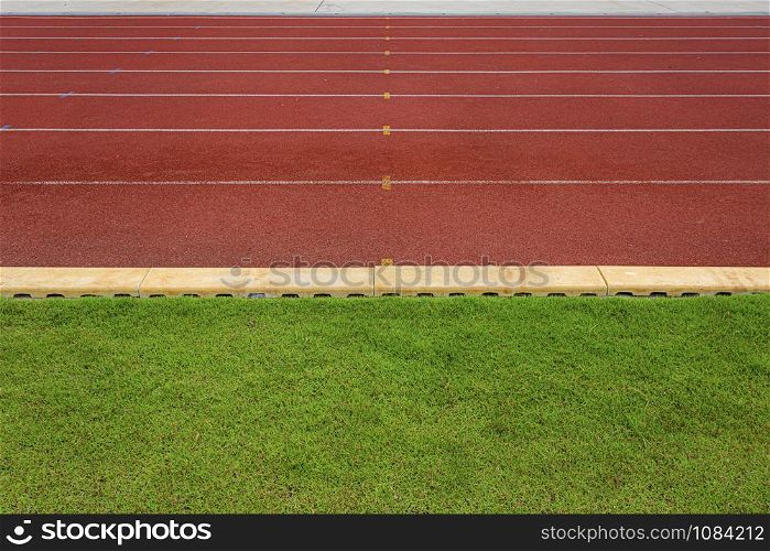 texture of running racetrack red rubber racetracks in outdoor stadium are 8 track and green grass field,empty athletics stadium with track,football field, soccer field.