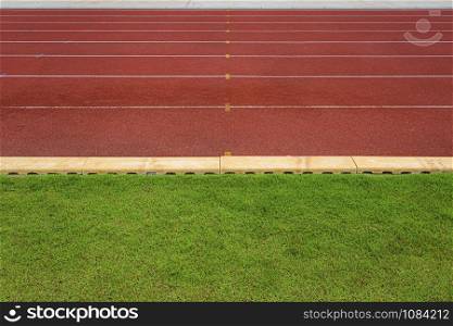 texture of running racetrack red rubber racetracks in outdoor stadium are 8 track and green grass field,empty athletics stadium with track,football field, soccer field.