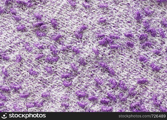 Texture of the knitted fabric. Knitting from yarn, handmade. A pattern of color white and purple yarn, background.. Texture of the knitted fabric. Knitting from yarn, handmade. A pattern of color white and purple yarn, background