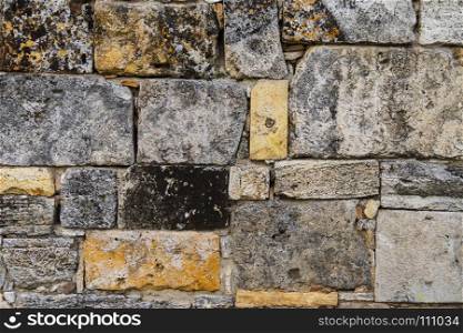 Texture of the wall made of different types of stone