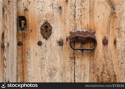 Texture of very old wooden door with keyholes and handle, Girona, Spain