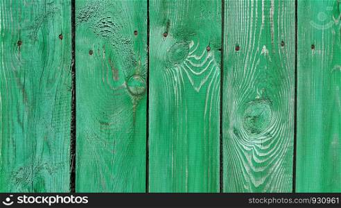 Texture of weathered wooden green painted fence, close-up vintage background