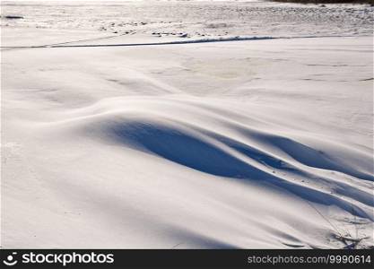 Textured snow patterns and snowdrift on the ground in a wintry landscape