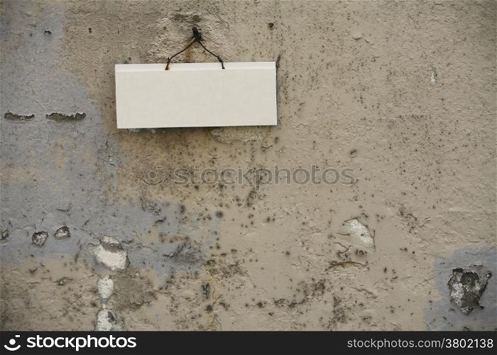 Textured Wall With a White Blank Sign