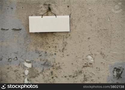 Textured Wall With a White Blank Sign
