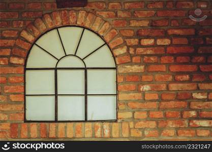 Textures and close up detailed patterns concept. Big rounded window on red brick wall. Big rounded window on red brick wall
