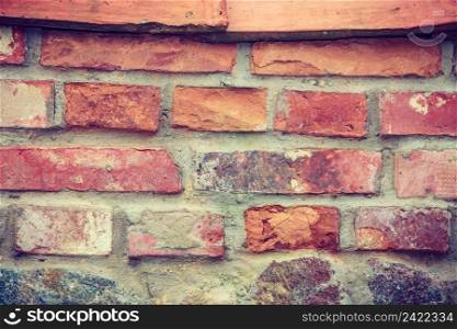Textures and close up detailed patterns concept. Red brick wall with wooden pieces. Red brick wall with wooden pieces