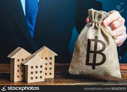 Thai baht money bags and residential buildings figures. Investments in real estate and construction industry. Bank offer of mortgage loan. Taxes. Rental business. Sale of housing. Municipal budget.