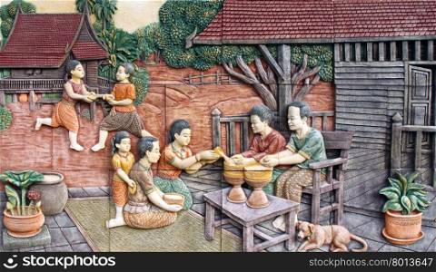 Thai culture of Songkran festival stone carving on temple wall