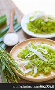 Thai dessert - pounded unripe rice food rice flakes cereal with coconut and sugar, Green rice sweet with ears of rice pandan leaf, Food dessert or snacks - Khao Mao name in Thailand 